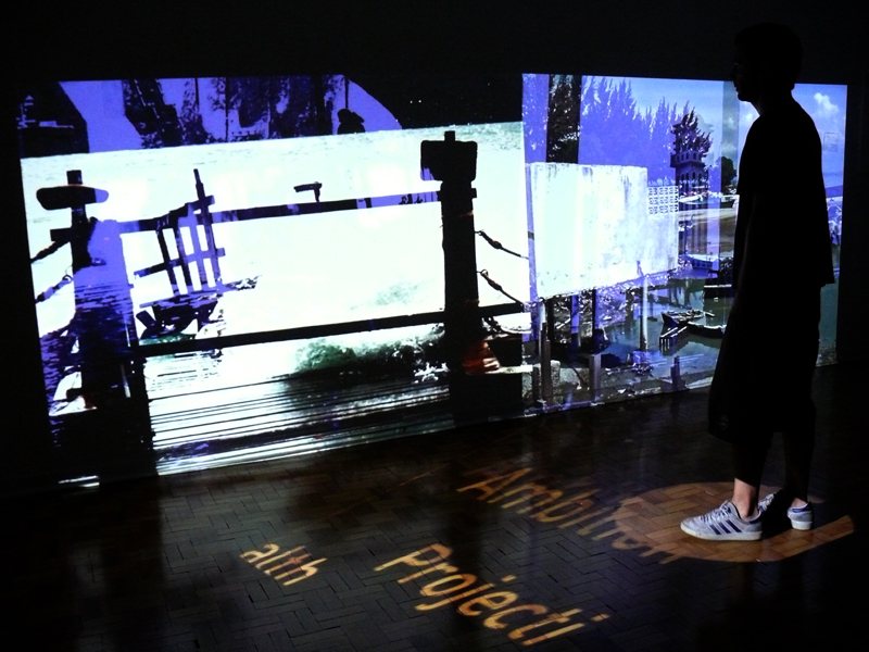 A visitor in front of the Oracle's large projected screens, with words projected onto the floor